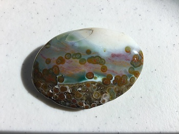 Palm stone likely from Vein 1, featuring a colorful porcelain chalcedony and gray aggregate matrix with floating semi-translucent orbs, length ~2.375in