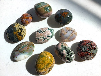 Set of polished palm stones of every color: green, white, gray, cream, tan, brown, yellow, orange, pink, red, purple, blue, black
