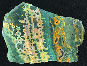 Figure 2: Unpolished (wetted) Ocean Jasper slab, likely from early Kabamby collection sites, 2003 or earlier. This specimen is similar to that shown in Fig. 2 in Lieber. The reddish color in these specimens are from ubiquitous iron oxide/hydroxide particulates, as explained in the Figure 1 caption. I have verified by lab analysis (EDX, XRD) that Kabamby specimens are chalcedony quartz with well-defined XRD profiles and trace iron content peaks (EDX). Specimen length: ~15cm.