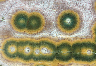 Figure 5 (Left): Closeup of a Kabamby specimen, showing multiple intermeshed spheres, several cut in the middle. Once again showing the ubiquitous iron oxide/hydroxide particulate flow common in these and Marovato specimens. Similar to Lieber's Fig. 5 (Left). Picture length ~20mm. 